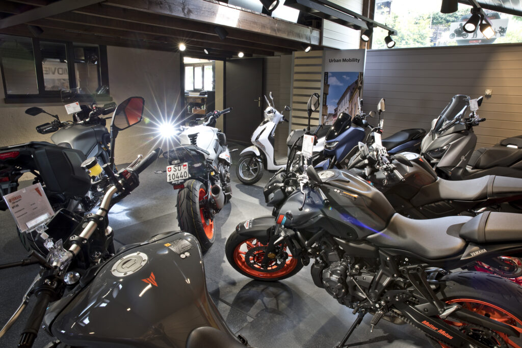 Grosser Yamaha Showroom in der Motorradwerkstatt von Matter Motos mit aktuellen Modellen: MT-09, Tracer 9 GT, TMAX Tech MAX, NMAX und weitere Roller. Helle Beleuchtung, professionelle Präsentation und freundliche Atmosphäre.